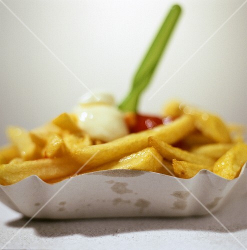 Chips with ketchup and mayonnaise in cardboard dish