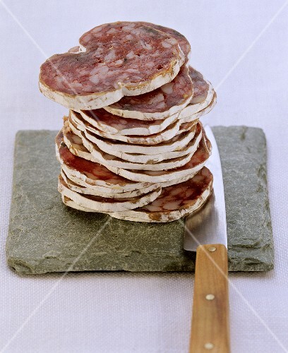 Farmhouse salami, sliced, on flat stone