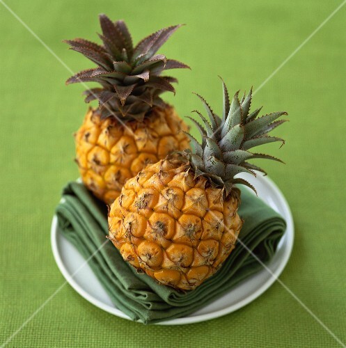 Two baby pineapples on a plate