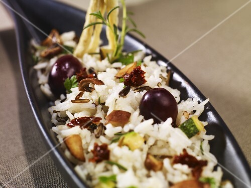 Rice dish with chestnut mushrooms, courgettes, black olives & dried tomatoes