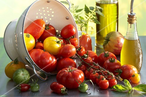Various types of tomatoes with a colander