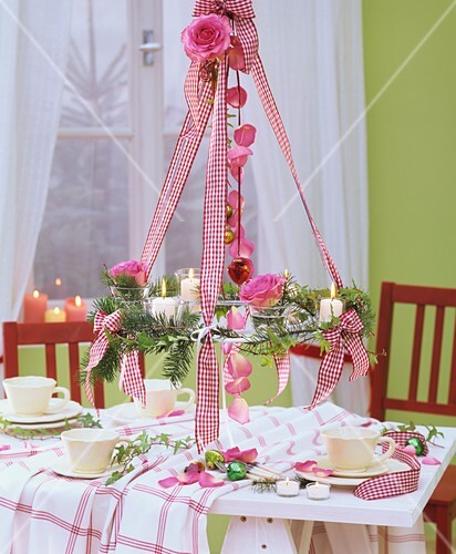 Hanging wreath of Douglas fir & roses above Christmas table