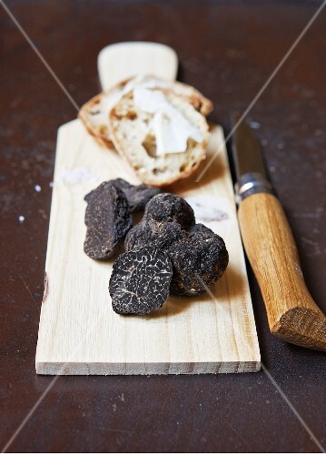 Black truffles on a wooden board