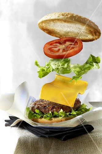 Hamburger and ingredients being stacked