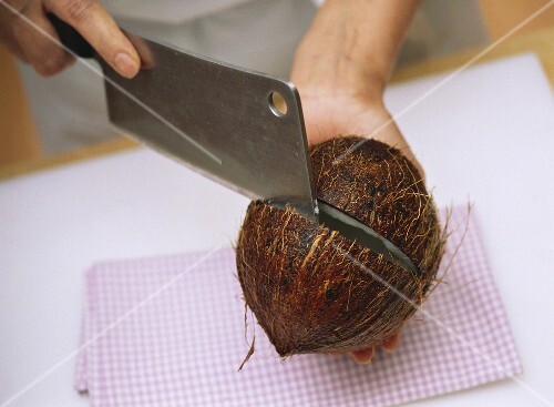 Cutting open a coconut with a cleaver