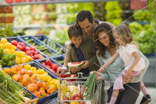 Family at the vegetable counter in a supermarket