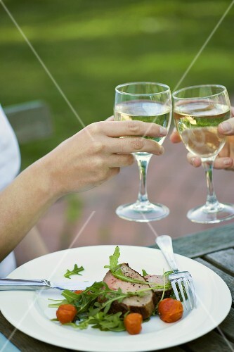 Clinking white wine glasses together