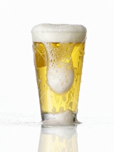 Overflowing glass of beer