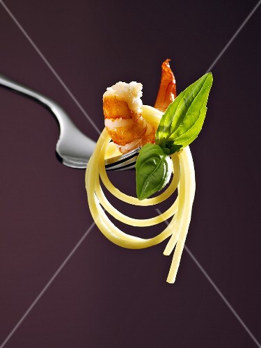 Spaghetti with shrimp and basil on a fork