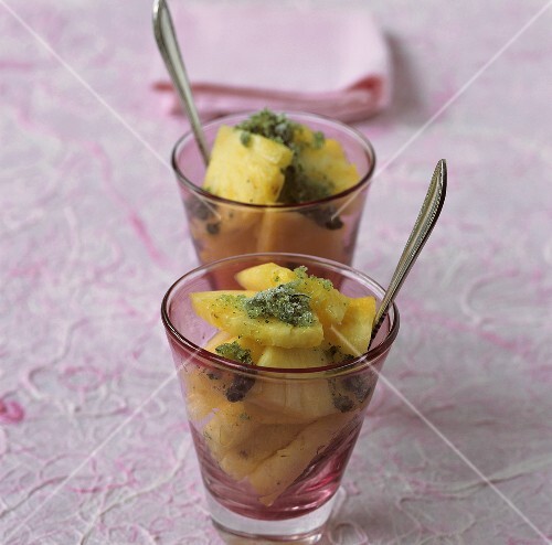 Pieces of pineapple with mint granita in two glasses