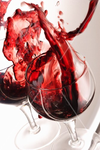 A glass of red wine spilling