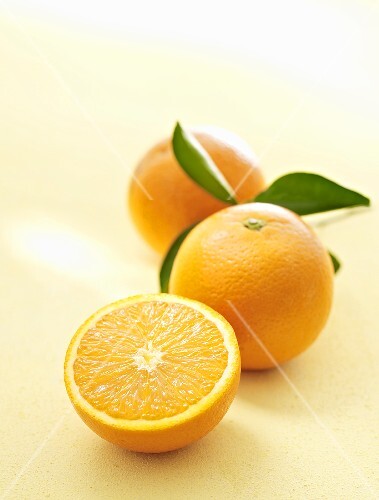Oranges, whole and halved, with leaves