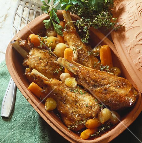 Turkey legs with carrots and shallots in Romertopf
