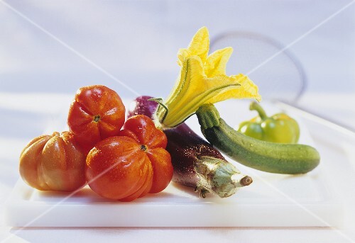 Washed tomatoes, courgette with flower and aubergine