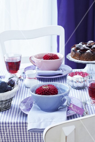 A table laid with dahilas in cups