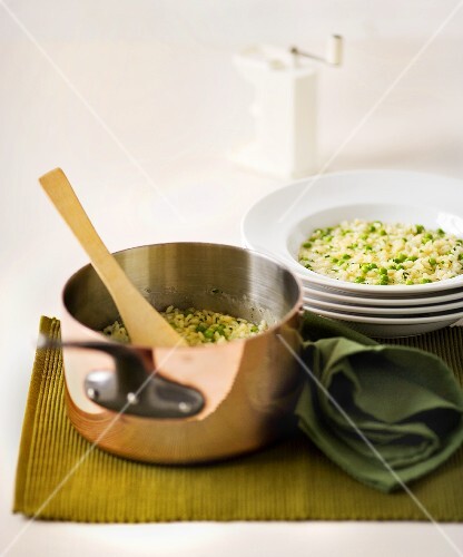 Erbsenrisotto im Kupfertopf und auf Teller