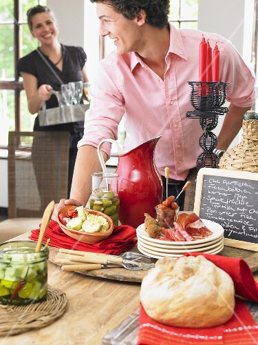 Man and woman serving food and drinks at a tapas buffet
