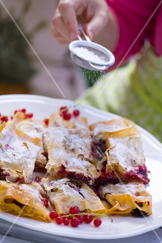 Redcurrants in filo pastry being dusted with icing sugar