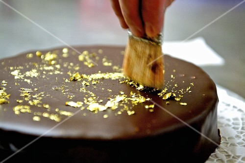 Schokoladentorte mit blattgold verzieren – stockfood Essen verzieren