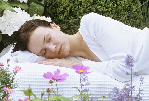 Young woman asleep in garden