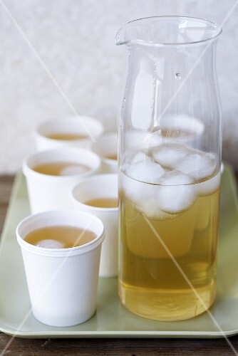 Elderflower liqueur with ice in carafe and paper cups