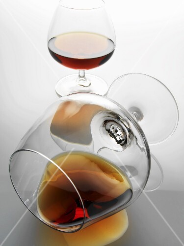 Two glasses of brandy, one spilt