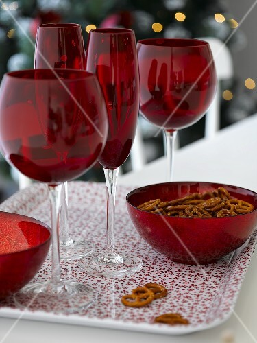 Salted pretzels and red glasses on tray