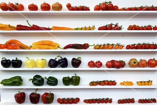 Various tomatoes and pepper on a shelf