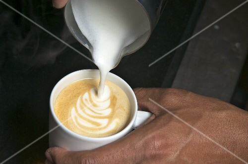 Milk foam being poured onto espresso