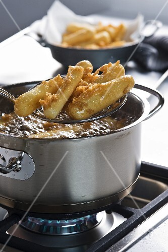 Battered black salsify being fried in hot oil