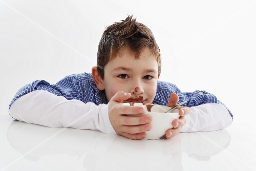 Small boy eating chocolate pudding