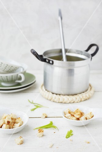A pot of soup with croutons in bowls
