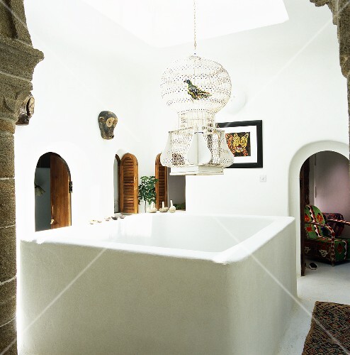 An ornamental birdcage hangs over the central well of the house
