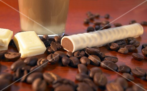 A chocolate latte, a macchiato stick and coffee beans
