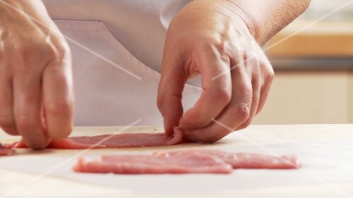 Veal escalope being tenderized with the balls of the hand