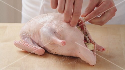 Duck being filled with onion and apple stuffing (German Voice Over)