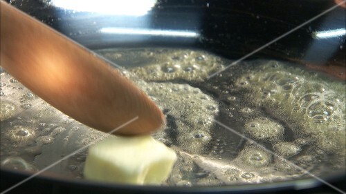 Melting butter in a frying pan and sweating pearl onions
