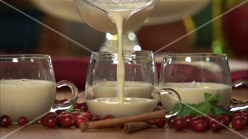 Pouring eggnog into a glass cup