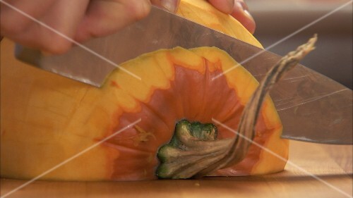 Slicing a peeled pumpkin half