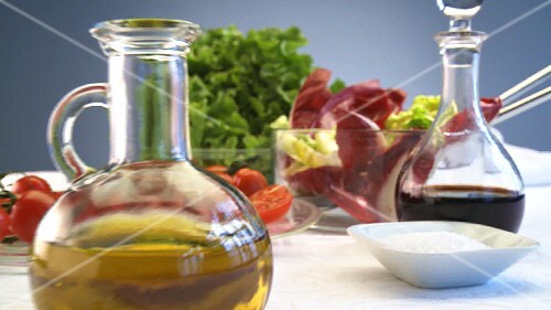 Salad, oil and vinegar on table