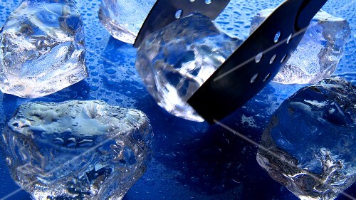 Putting ice cubes into a glass