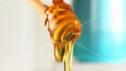 Honey running over honey dipper