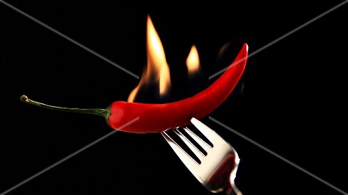 Chilli speared on fork, catching fire