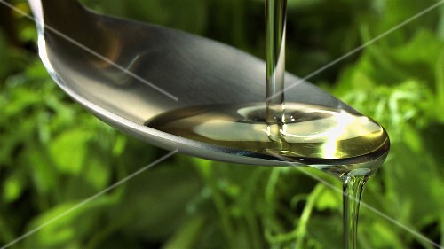 Olive oil running over a spoon