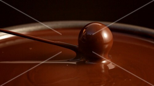 Lifting a chocolate out of chocolate couverture