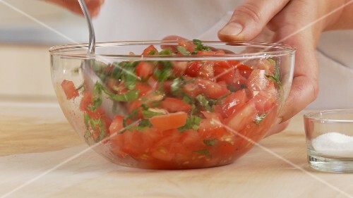 Basil and tomatoes being mixed together