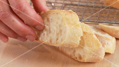 Ciabatta slices being placed on an oven rack