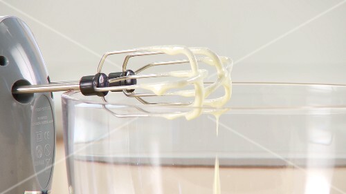 Eiercreme tropft von den Rührhaken