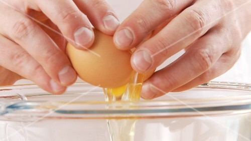 Frische Eier in eine Schüssel aufschlagen
