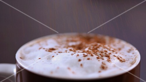 Milchschaum mit Kakaopulver bestäuben
